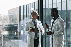 two doctors in conversation outside of a hospital 