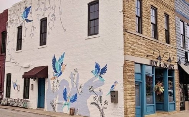 Historic Lebanon Main Street Revitalization Corner storefront with painted mural of blue birds and plants on the exterior wall beside a neighboring shop entrance.