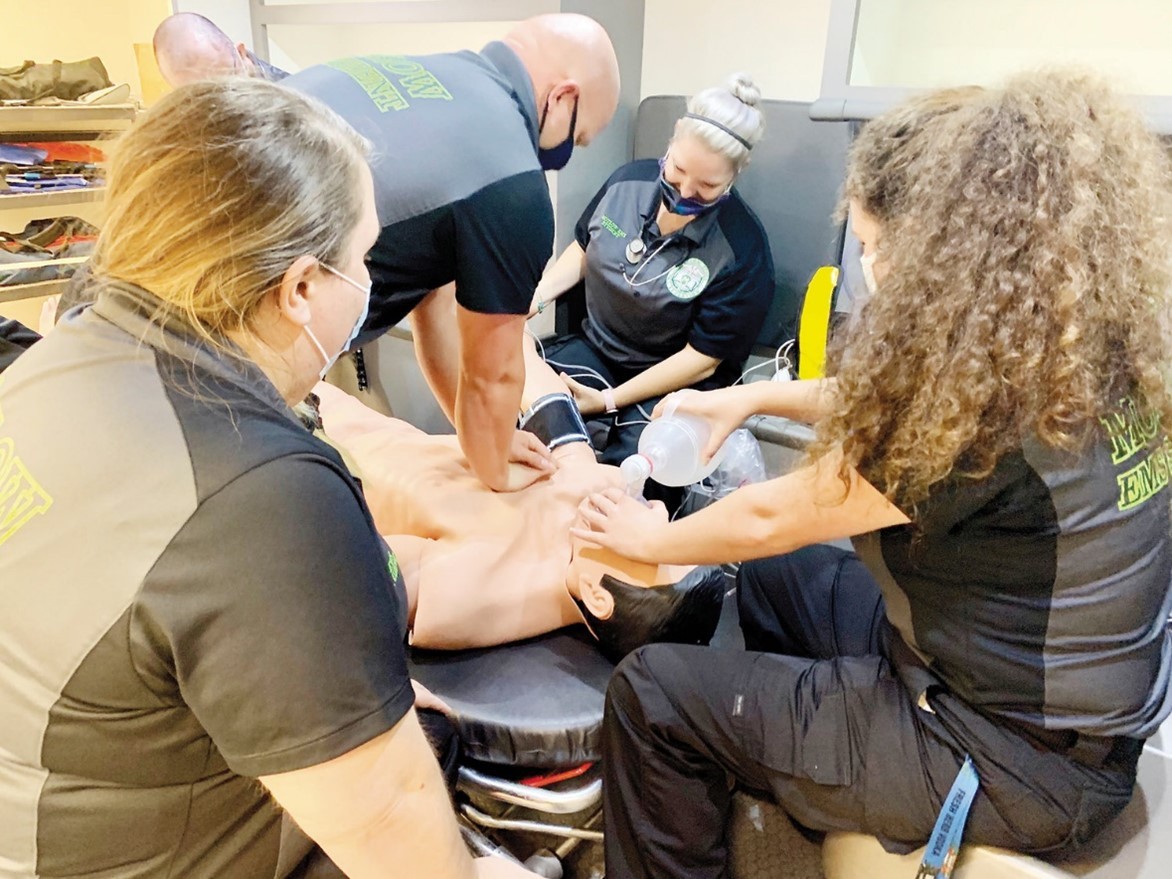 White County Emergency Medical Services Education Course Emergency responders practice lifesaving techniques on a medical training mannequin indoors.