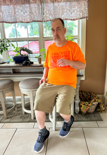 Charles "Lee" Matthews sits on a high-top chair in a t-shirt and shorts.