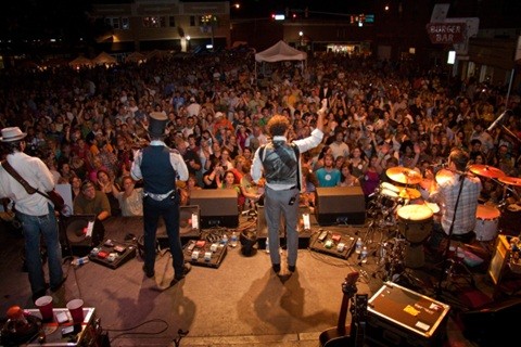 Musicians on stage at an outdoor concert