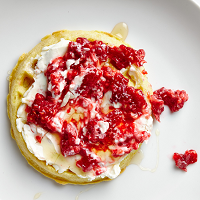 waffle with cream cheese and raspberries smashed on top