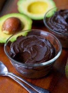 Avocado Chocolate Mousse avocado chocolate mousse in a small serving dish with avocado in the background
