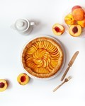 peach_pie_filling Overhead view of a peach pie with cut fresh peaches around it
