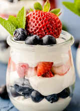 layers of yogurt, blueberries and strawberries in a glass
