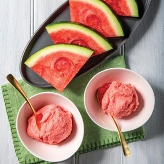 Watermelon Whip watermelon whip in two white bowls in the foreground; in the background is platter of sliced watermelon