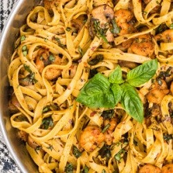 spicy pesto shrimp pasta with basil garnish on top