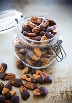 Chocolate Dipped Nut a small jar of assorted nuts that are each half dipped in dark chocolate