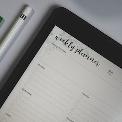 A weekly planner with a pen A weekly planner with a pen