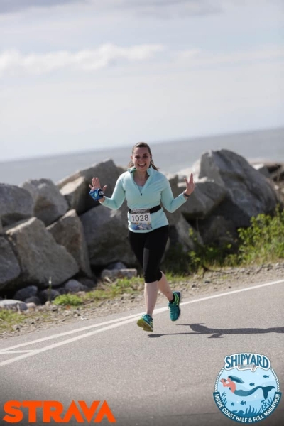 Corinne running a race, smiling and looking at the camera