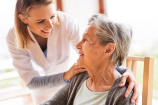 Elder Safety Nursing Homes Woman has hands on shoulders of an older woman