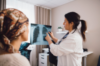 X-rays Doctor shows X-ray to a woman wearing a headscarf