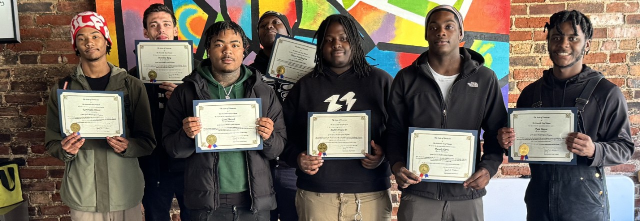 A group of students hold certificates
